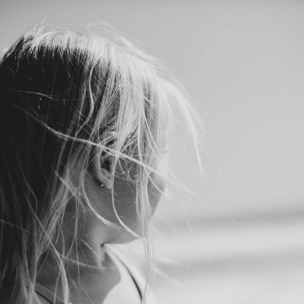 A serene person stretching gently outdoors with a soft focus background.